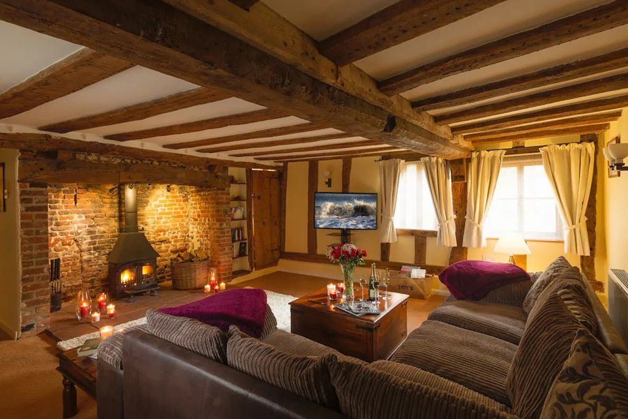 Lounge with large inglenook fireplace and exposed beams.
