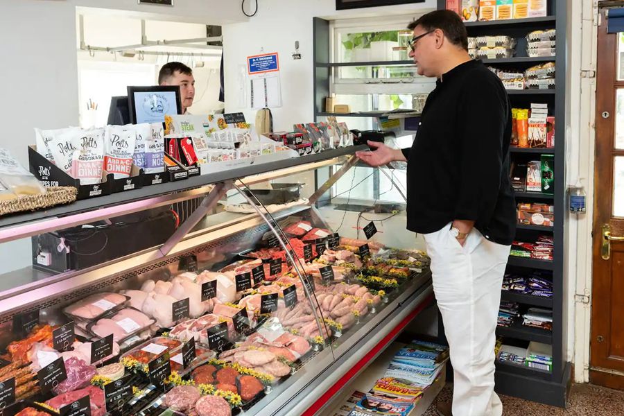 A customer finds it hard to choose from such a wide selection of beautifully presented meat in Rolfes butcher, close to the cottage
